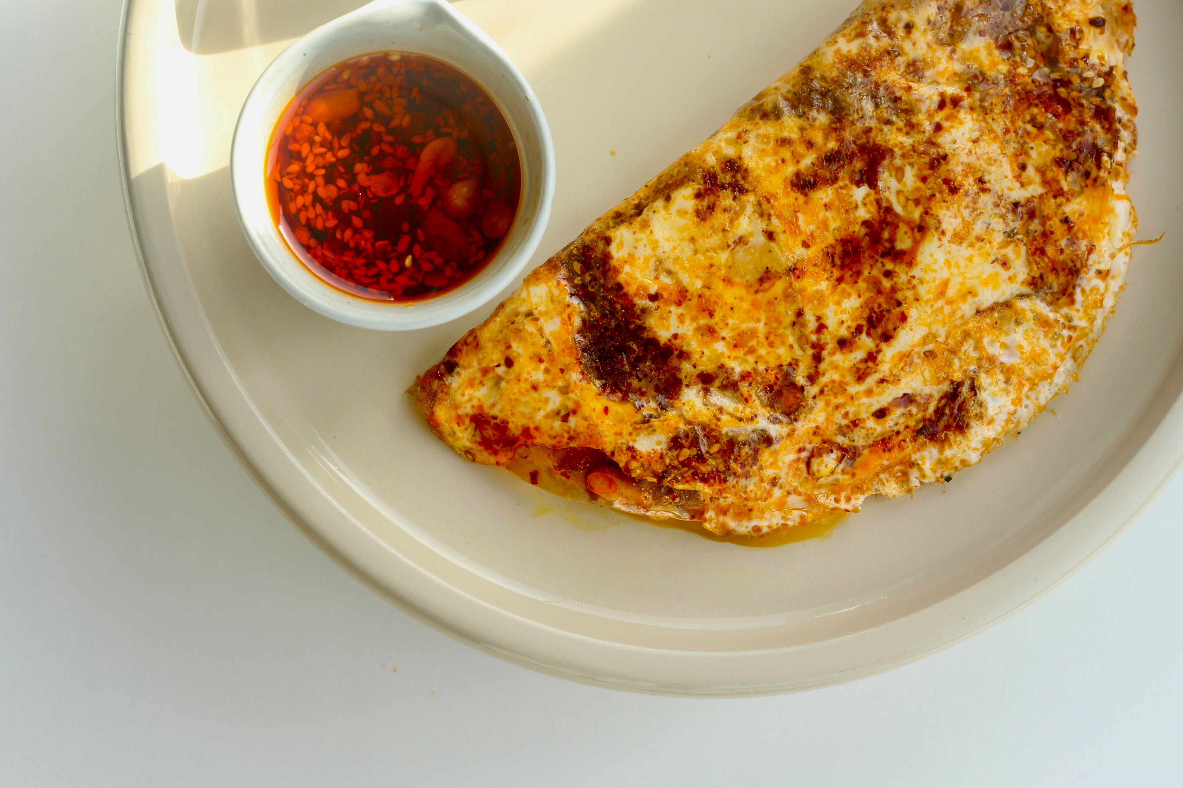 A delicious picture of a Rice Paper Omelette with White Mausu Extra Hot Peanut Rāyu.